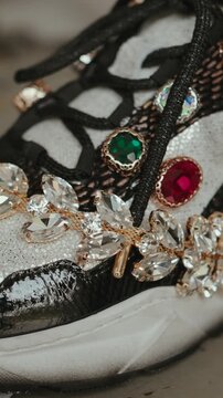 Vertical macro of jeweled designer shoe with crystals and gold detail