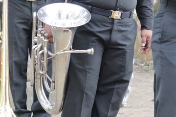 A marching band member stands holding a euphonium.