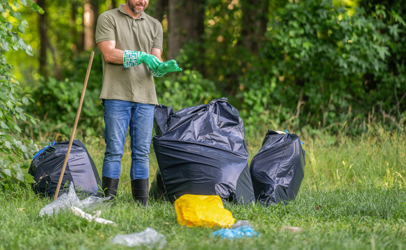 Volunteer collecting trash in the forest into garbage bag. Environmental protection. Environmental activist. Environmental conservation and waste pollution. Environment plastic pollution cropped view