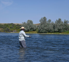 A man fly fishing for trout on a western river.