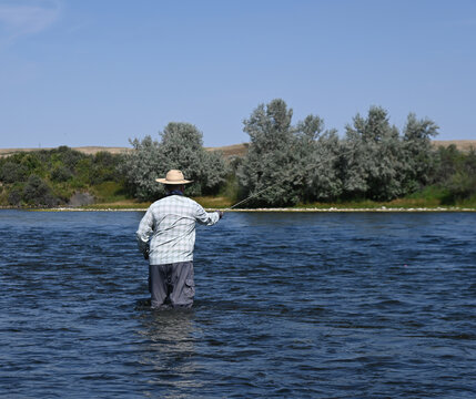 A man fly fishing for trout on a western river.