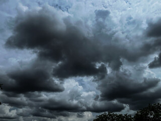 The dark sky with heavy clouds converging and a violent storm before the rain.Bad or moody weather sky and environment. carbon dioxide emissions, greenhouse effect, global warming, climate change.