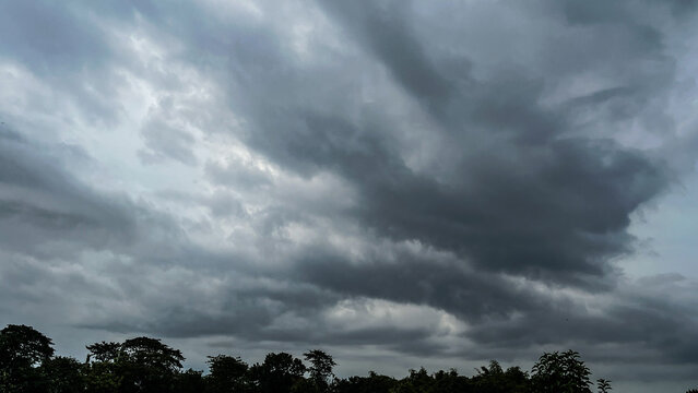 The dark sky with heavy clouds converging and a violent storm before the rain.Bad or moody weather sky and environment. carbon dioxide emissions, greenhouse effect, global warming, climate change.