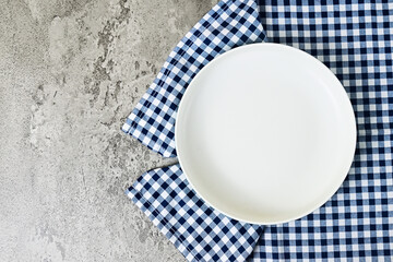 Top view of empty white plate with napkin. Grey or gray cement on the background. copy space, empty, free, negative, text, design. flat lay. high angle, above.