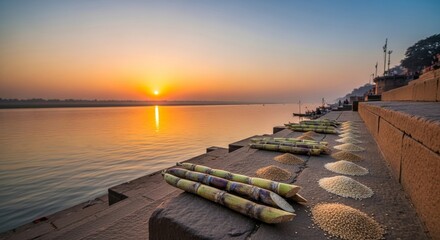 Makar Sankranti sunrise over Ganga river, sugarcane and sesame offerings on stone steps