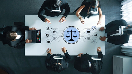 A diverse group of business professionals engages in a virtual reality meeting around a table. The justice symbol in the center represents legal discussions and innovation in a modern workspace. Trope