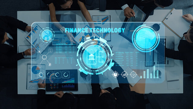 A business team engages in collaboration over a finance technology dashboard, using data visualizations and insights for strategic planning in a modern office setting. Trope