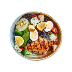 A vibrant and healthy grilled chicken salad bowl brimming with fresh vegetables lemon slices and hard boiled eggs presented in a rustic ceramic dish