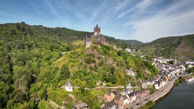Aerial footage flying toward Reichsburg Cochem, a medieval hilltop castle overlooking the historic town and the winding Moselle River.