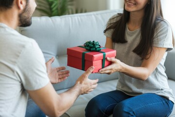 Woman giving red gift box present to man celebration happy couple anniversary surprise birthday love holiday