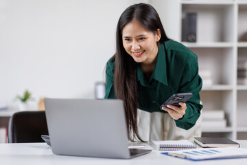 Business asian woman having phone conversation with client in office. young woman using smart phone. Woman Hands Using Mobile Phone in the Office
