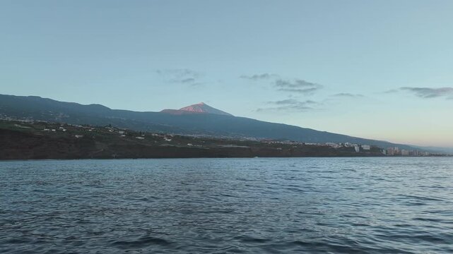 View from the sea of the coastline and village of Masca. In the background, Mount Taide illuminated by the sun. Tenerife