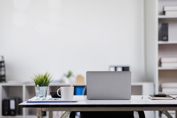 Modern office workplace with laptop computer, coffee cup and office supplies laptop office.
