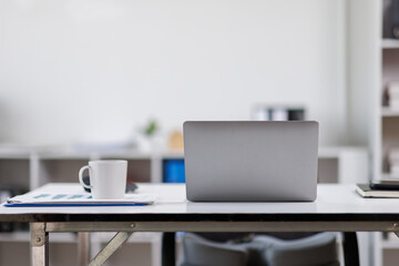 Modern office workplace with laptop computer, coffee cup and office supplies laptop office.
