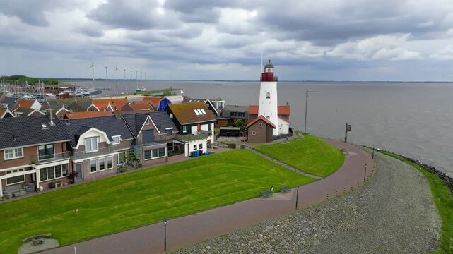 Aerial view of Scenic town of URK with historic lighthouse also known as Vuurtoren van and marina during cloudy day in The Netherlands