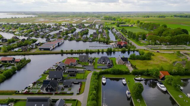 Aerial view of many luxury homes uniquely built middle of the lakes and canals in The Netherlands countryside.