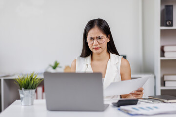 Asian Female Using Laptop Computer Focused Woman Working with Documents at Desk
