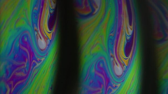 Rainbow soap flow. Mystical paint. Colorful duplicated arch emulsion transition oil dye mixing texture. Blur background black space.