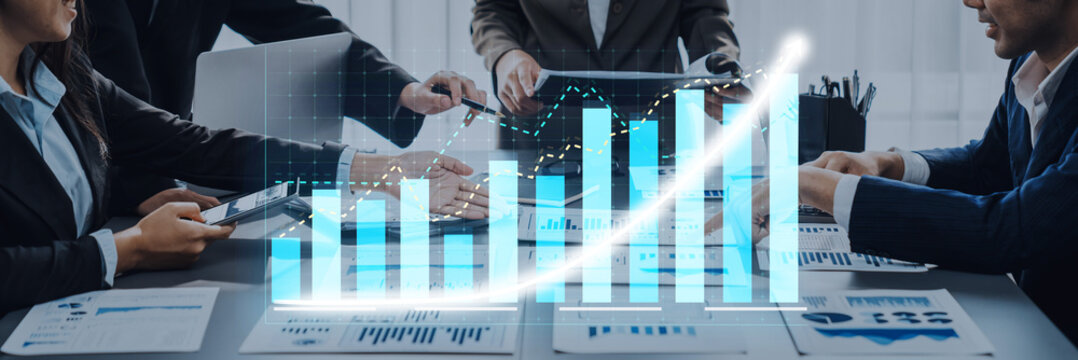 A dynamic business meeting showcases professionals collaborating over growth charts and financial data. The modern office atmosphere emphasizes teamwork and strategy. Axiom