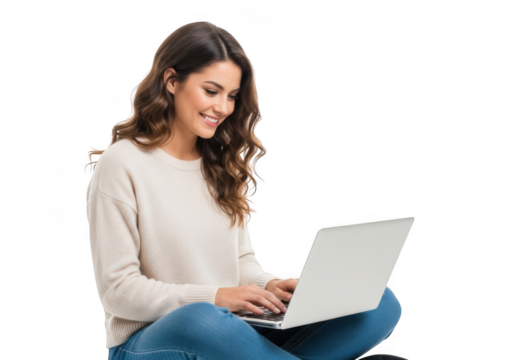 Young woman with long wavy brown hair smiling while typing on a laptop computer while sitting cross legged isolated on transparent background