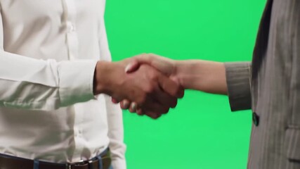 Closeup of two business people shaking hands on a green screen background symbolizing agreement partnership and successful collaboration in a professional setting ideal for corporate and commercial p.