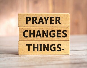 Stacked blocks spell "PRAYER CHANGES THINGS." on wood