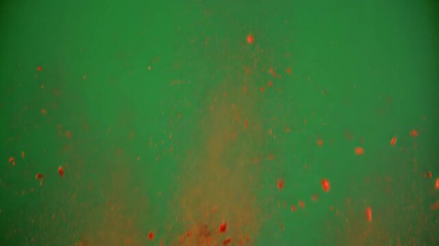 Exploding vibrant orange powder against a seamless green screen backdrop, ideal for special effects, visual elements, and creative projects needing dynamic color bursts