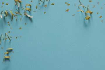close up on group of gold color of rolling ribbon and confetti on teal background with copy space for christmas festival happy new year ,carnival , birthday and anniversary, concept design