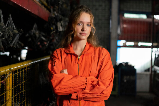 Technician female worker working in garage scrap yard auto warehouse.
