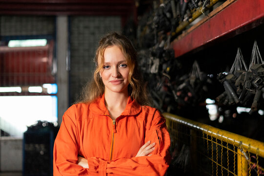 Technician female worker working in garage scrap yard auto warehouse.
