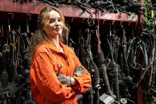 Technician female worker working in garage scrap yard auto warehouse.
