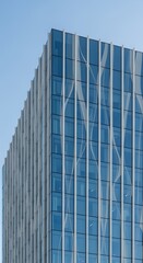Fototapeta premium Looking Up at a Modern Glass Building with Metal Trim Under Clear Blue Sky