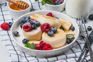 Cheesecakes with powdered sugar and berries on a plate