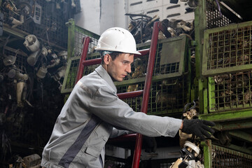 Technician worker working and checking in garage scrap yard car workshop warehouse.