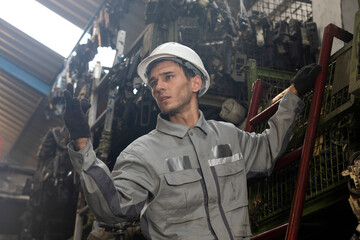 Technician worker working and checking in garage scrap yard car workshop warehouse.