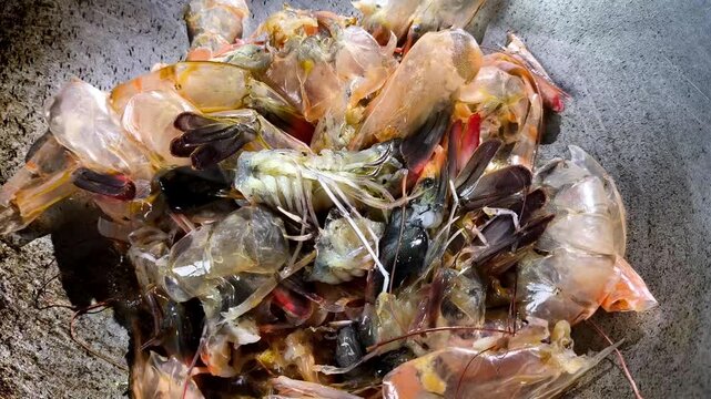 Frying prawn shells in pan, indoor Chiangmai Thailand.