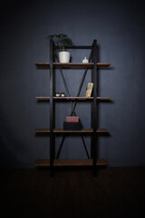 Loft-style interior with metal bookcase. Modern minimalist shelving with wooden shelves on a dark background