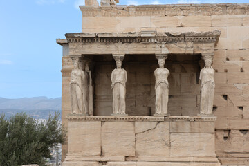 Fototapeta premium Ancient Caryatids of the Erechtheion on the Acropolis in Athens, showcasing classical Greek architecture, marble detail and historic cultural heritage