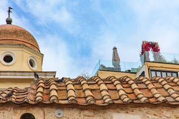 Naklejka premium Historic Pantanassa Church in Monastiraki Square, Athens, with pigeons on the old tiled roof. Ancient architecture, city life and Greek heritage
