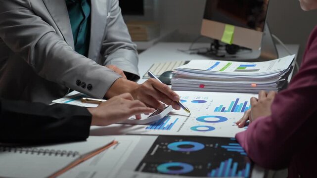 Business team analyzing financial data charts and graphs at night