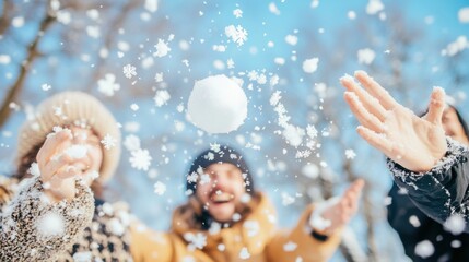 Happy friends enjoying a playful snowball fight in a snowy winter park, with a snowball in mid-air and falling snowflakes.