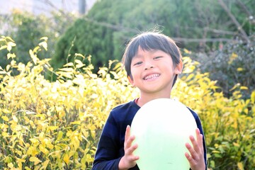 秋の日差しの下で笑顔で楽しそうにしている小学生の男の子 アジアの日本人の子ども