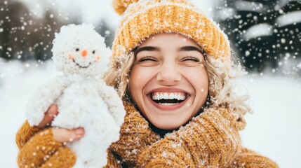 Joyful woman in winter outfit smiling while holding a knitted snowman in falling snow.