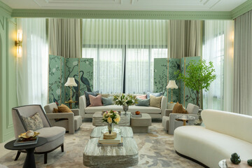 Interior of a luxurious sitting room with bay window sofas and coffee table. White and green tone of vast luxury living room.
