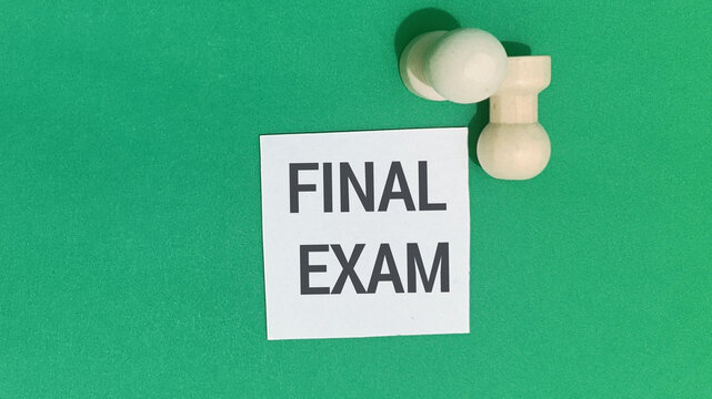 Final Exam Note on Green Background with Wooden Pawn