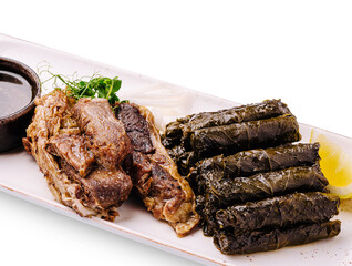 Delicious grilled meat and wrapped vine leaves served on a white plate