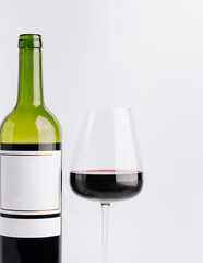 Red wine bottle and glass on a simple background for tasting experience