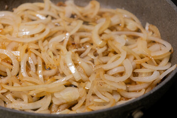 caramelizing onion slices in a pan
