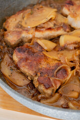 delicious pork chop with onion and apples in pan fall meal