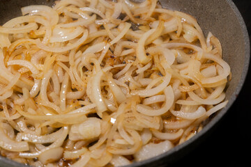 caramelizing onion slices in a pan